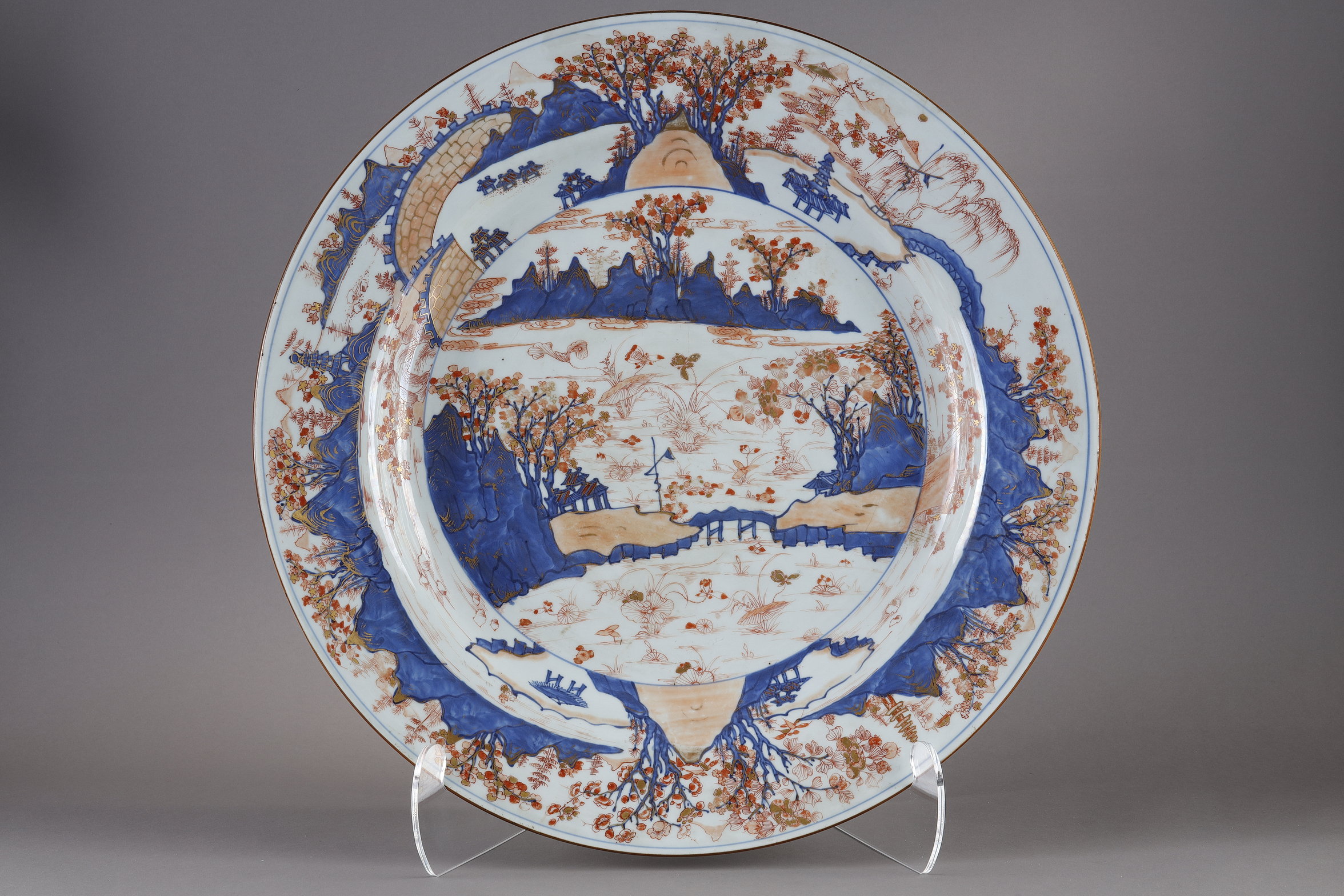 Very large dish porcelain decorated in blue under glaze in iron red and gold of a landscape with a fort and a lake with many lotus. China Kangxi around 1710            (diam 62cm)